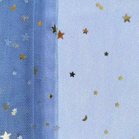 Un gros plan du "Tissu tulle lune et étoiles au mètre" de Longan Craft France montre des confettis d'étoiles et de lunes dorées sur une maille pailletée multicolore, idéale pour les costumes de scène. L'éclairage uniforme révèle la texture détaillée du tulle.