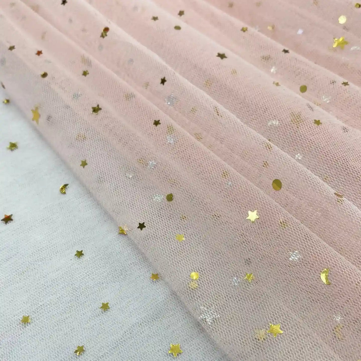 Gros plan sur Tissu tulle lune et étoiles au mètre de Longan Craft France, un tulle multicolore pailleté orné de sequins étoiles et pois dorés et argentés. Idéal pour costumes de scène ou robes, vendu au mètre.