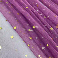 Gros plan sur le Tissu tulle lune et étoiles au mètre de Longan Craft France : tulle pailleté multicolore avec des étoiles métalliques dorées, une texture froncée et un soupçon de maille blanche. Parfait pour les costumes de scène.