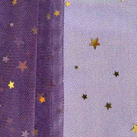 Gros plan sur "Tissu tulle lune et étoiles au mètre" de Longan Craft France : maille violette à gauche, blanche à droite, toutes deux ornées de paillettes étoiles dorées - idéal pour les costumes de scène et les créations magiques.