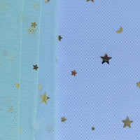 Gros plan sur le "Tissu tulle lune et étoiles au mètre" de Longan Craft France, un tissu de tulle pailleté multicolore idéal pour les costumes de scène, superposé sur une surface et décoré de confettis d'étoiles et de lunes dorées.