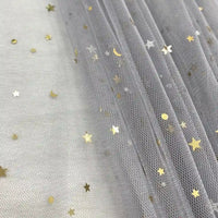 Le "Tissu tulle lune et étoiles au mètre" de Longan Craft France est un tulle pailleté multicolore, idéal pour les costumes de scène, qui présente des étoiles et des croissants de lune métalliques éparpillés sur un tissu doux et drapé.