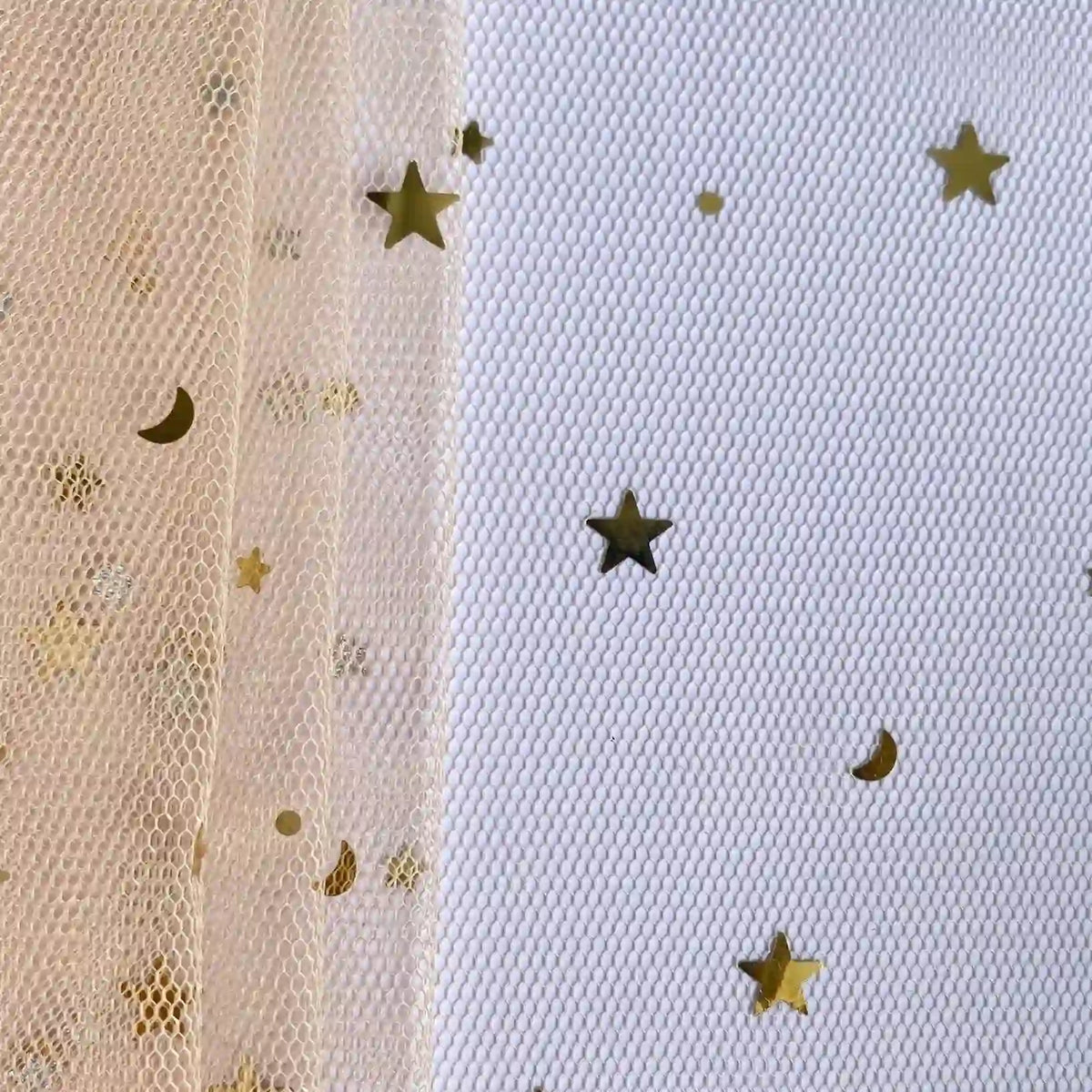 Gros plan sur le Tissu tulle lune et étoiles au mètre de Longan Craft France en beige transparent avec des motifs d'étoiles et de croissants dorés à gauche, à côté d'un pailleté de tulle en maille blanche orné d'étoiles multicolores scintillantes.