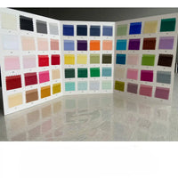 Un livre d'échantillons ouvert de Longan Craft France présente des échantillons numérotés de tissu organza multicolore en pure soie de mûrier de 8 momme, présentant une variété de nuances pour la couture de luxe sur une surface brillante.