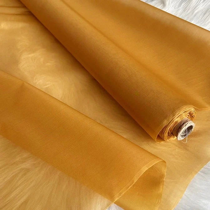 Un rouleau d'Organza de soie multicolore 8 momme au mètre de Longan Craft France est présenté sur une surface blanche. Il s'agit d'une pure soie de mûrier légère et translucide, parfaite pour les robes de luxe.