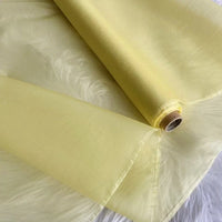 Un rouleau d'Organza de soie multicolore 8 momme de Longan Craft France, fabriqué à partir de pure soie de mûrier, est présenté déroulé sur une surface texturée blanche - son luxe transparent et léger est idéal pour les robes de chambre et les robes de soirée élégantes.