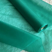 Un rouleau de tissu en pure soie de mûrier "Organza de soie multicolore 8 momme au mètre" de Longan Craft France est partiellement déroulé pour révéler sa texture diaphane, légère et lisse, luxueuse pour la confection de robes élégantes.
