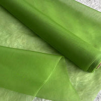 Un rouleau d'Organza de soie multicolore 8 momme au mètre de Longan Craft France est présenté déroulé sur une surface texturée blanche, mettant en valeur sa pure soie de mûrier délicate, translucide et brillante, idéale pour les robes de luxe.