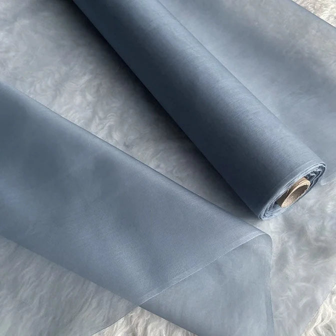 Gros plan sur deux rouleaux d'Organza de soie multicolore 8 momme semi-transparent et gris clair de Longan Craft France - un tissu luxueux en pure soie de mûrier, idéal pour confectionner des robes élégantes.