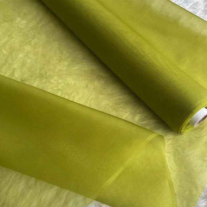 Deux rouleaux d'Organza de soie multicolore 8 momme de Longan Craft France, un tissu en pure soie de mûrier pour robes de luxe, sont partiellement déroulés pour mettre en valeur leur texture lisse et translucide.
