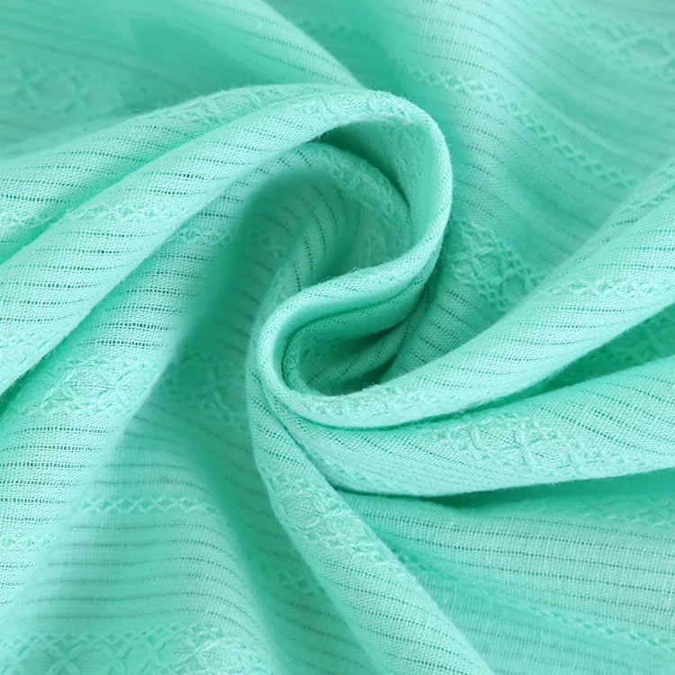 Gros plan sur le Tissu dobby coton multicolore au mètre de Longan Craft France, montrant son motif rayé texturé et son drapé doux - un dobby textile idéal et confortable pour les chemises et les vêtements.
