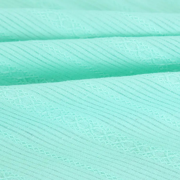 Gros plan sur le Tissu dobby coton multicolore au mètre de Longan Craft France, montrant son motif texturé à rayures et ses coutures fines - idéal comme textile confortable pour chemises.