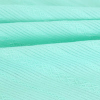 Gros plan sur le Tissu dobby coton multicolore au mètre de Longan Craft France, montrant son motif texturé à rayures et ses coutures fines - idéal comme textile confortable pour chemises.