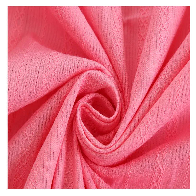 Gros plan sur le Tissu dobby coton multicolore au mètre de Longan Craft France : un tissu texturé et rayé avec des motifs en forme de dentelle, doux et léger, parfait pour les chemises confortables et les projets de vêtements détaillés.