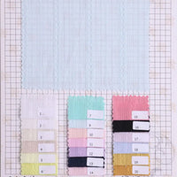 Une carte d'échantillons de tissu de Longan Craft France montre un grand Tissu dobby coton multicolore au mètre en haut et 20 échantillons numérotés et multicolores de ce textile rayé texturé pour chemises, disposés en trois rangées sur une grille.