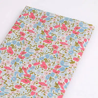 Le Tissu linon de coton léger au mètre de Longan Craft France présente un imprimé floral multicolore idéal pour la confection de vêtements d'été, exposé à plat sur fond blanc.