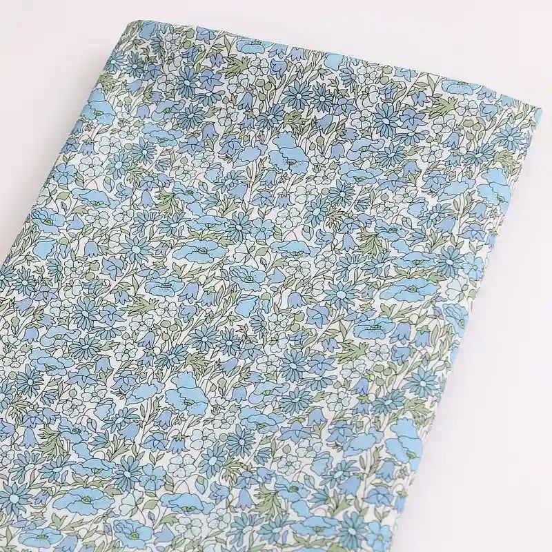 Tissu léger en coton linon de Longan Craft France, présentant un imprimé floral multicolore sur un fond clair - idéal pour les vêtements d'été. Disponible au mètre.