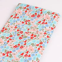Le Tissu linon de coton léger au mètre de Longan Craft France présente un imprimé floral multicolore sur fond blanc et est idéal pour les vêtements d'été élégants et aérés.