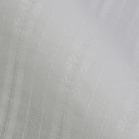 Gros plan sur le Tissu dobby leno multicolore de Longan Craft France, un tissu jacquard en coton avec de subtiles rayures verticales et de minuscules fleurs. Son tissage aéré en fait un tissu idéal pour les robes légères.