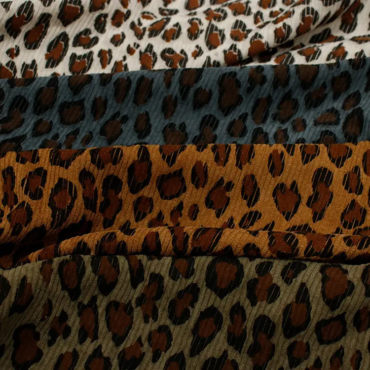 Le tissu côtelé imprimé léopard multicolore au mètre de Longan Craft France se compose de polyester velours côtelé doux avec des imprimés animaliers audacieux en blanc cassé, gris foncé, brun-orange et vert olive, parfaits pour les projets de vêtements remarquables.