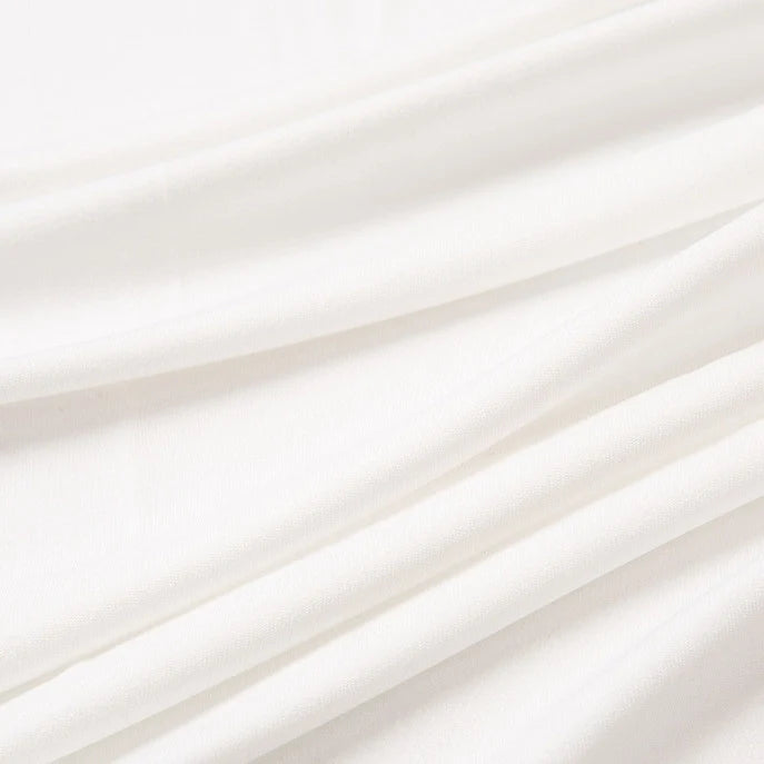 Gros plan sur le Tissu jersey polyester multicolore au mètre de Longan Craft France, un tissu jersey polyester-élasthanne souple et extensible pour robes, présenté avec des plis lisses et des ombres douces mettant en valeur sa texture.