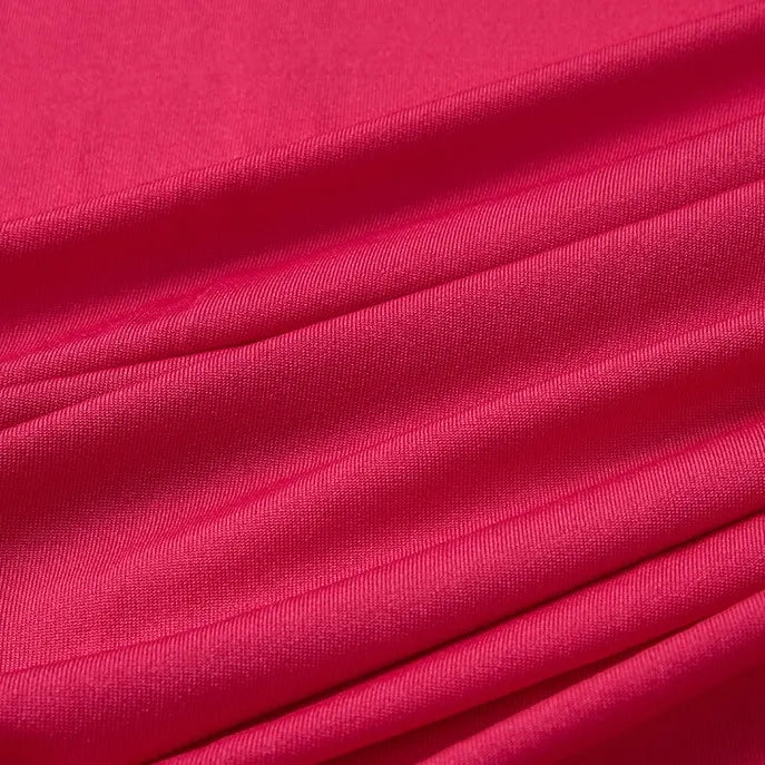 Gros plan sur le tissu Longan Craft France jersey polyester multicolore au mètre, montrant ses plis lisses et légèrement brillants et son tissage visible. Ce jersey polyester-élasthanne est doux, extensible et idéal pour la confection de robes.