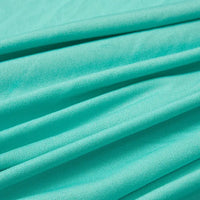 Gros plan sur le tissu jersey polyester-élasthanne multicolore au mètre de Longan Craft France, idéal pour les peignoirs, montrant sa texture visible et ses plis diagonaux souples.