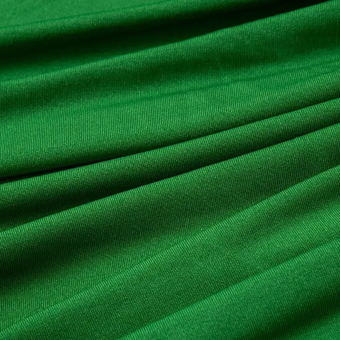 Gros plan sur le tissu jersey polyester-élasthanne multicolore au mètre pour peignoirs de Longan Craft France, montrant sa surface lisse et extensible avec une texture visible et des plis horizontaux, offrant confort et couleur vibrante.
