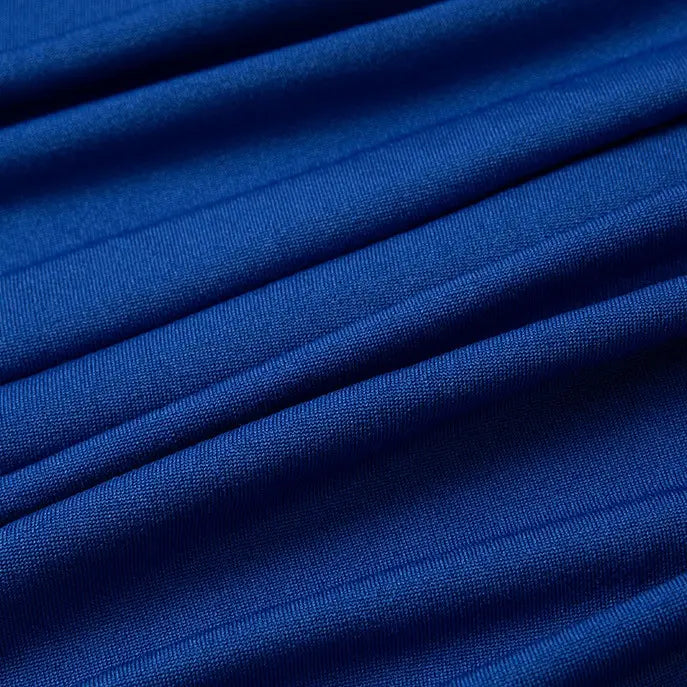 Gros plan sur le Tissu jersey polyester multicolore de Longan Craft France, montrant le tissage texturé et l'élasticité de ce tissu polyester-élasthanne, idéal pour les peignoirs. Disponible au mètre.