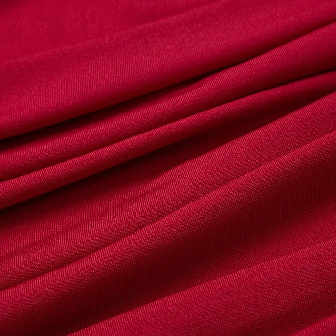 Gros plan sur le Tissu jersey polyester multicolore au mètre de Longan Craft France, qui présente un tissage lisse et régulier, des plis doux et une surface légèrement brillante - une matière parfaite en jersey polyester-élasthanne pour les peignoirs.