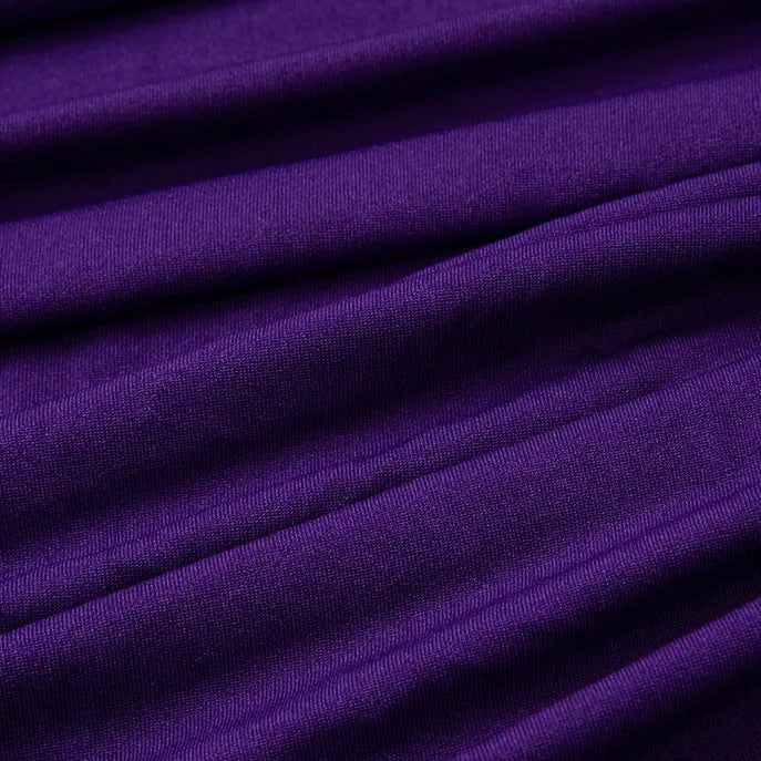 Un gros plan du Tissu jersey polyester multicolore au mètre de Longan Craft France montre des plis horizontaux visibles et une surface jersey polyester-élasthanne légèrement texturée, idéale pour la confection de robes.