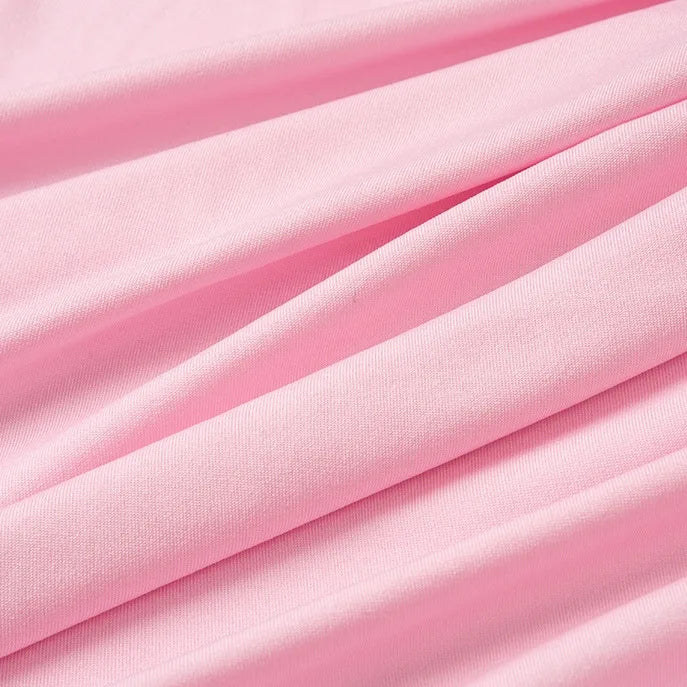 Un gros plan du tissu jersey polyester multicolore au mètre de Longan Craft France montre une texture lisse avec des plis doux formant des lignes diagonales, idéal comme matière jersey pour peignoirs.