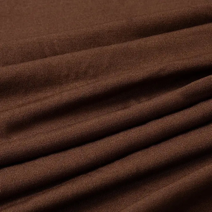 Un gros plan du Tissu jersey polyester multicolore au mètre de Longan Craft France montre sa surface texturée et ses plis horizontaux - parfait comme tissu jersey polyester-élasthanne pour les robes.