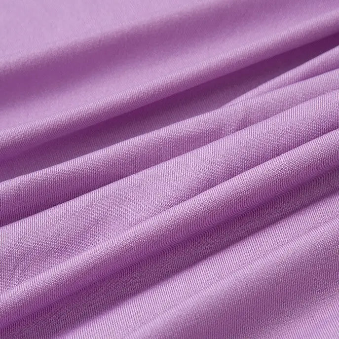 Gros plan sur le Tissu jersey polyester multicolore au mètre de Longan Craft France, montrant son jersey polyester-élasthanne finement texturé avec des plis horizontaux visibles - matière idéale pour la confection de peignoirs.