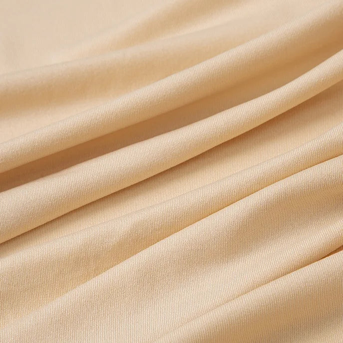 Un gros plan du jersey multicolore de polyester-élasthanne de Longan Craft France montre des plis diagonaux doux et une texture lisse et légèrement côtelée, mettant en valeur ce tissu léger et extensible pour les peignoirs.