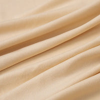 Un gros plan du jersey multicolore de polyester-élasthanne de Longan Craft France montre des plis diagonaux doux et une texture lisse et légèrement côtelée, mettant en valeur ce tissu léger et extensible pour les peignoirs.