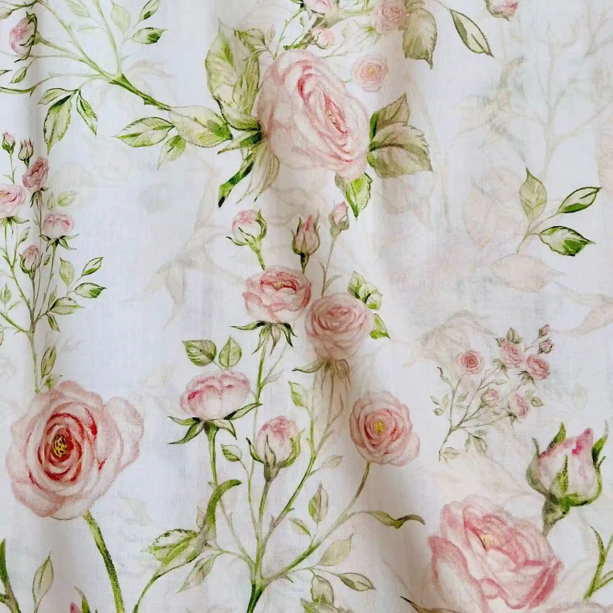 Un gros plan de Linon de coton imprimé multicolore au mètre de Longan Craft France montre un tissu de coton doux et floral avec des motifs de roses roses et de feuilles vertes sur fond blanc - idéal pour les amateurs de tissu linon de coton à fleurs et de motifs délicats inspirés de l'aquarelle.