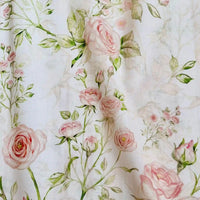 Un gros plan de Linon de coton imprimé multicolore au mètre de Longan Craft France montre un tissu de coton doux et floral avec des motifs de roses roses et de feuilles vertes sur fond blanc - idéal pour les amateurs de tissu linon de coton à fleurs et de motifs délicats inspirés de l'aquarelle.