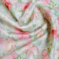 Le Linon de coton imprimé multicolore au mètre de Longan Craft France présente un motif floral doux et pastel de fleurs roses et de feuilles vertes sur fond bleu et blanc. Le drapé doux du tissu linon de coton à fleurs met en valeur ses plis naturels.
