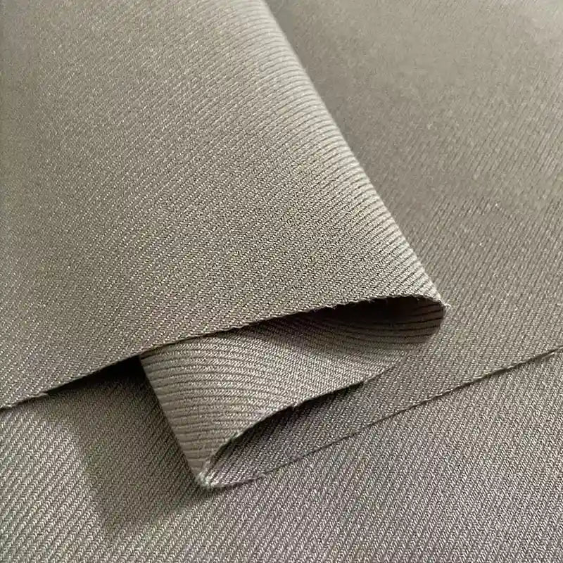 Gros plan sur la gabardine multicolore en viscose extensible de Longan Craft France, qui présente une fine texture côtelée en diagonale - parfaite pour les uniformes ajustés - pliée et présentée sur une surface plane.