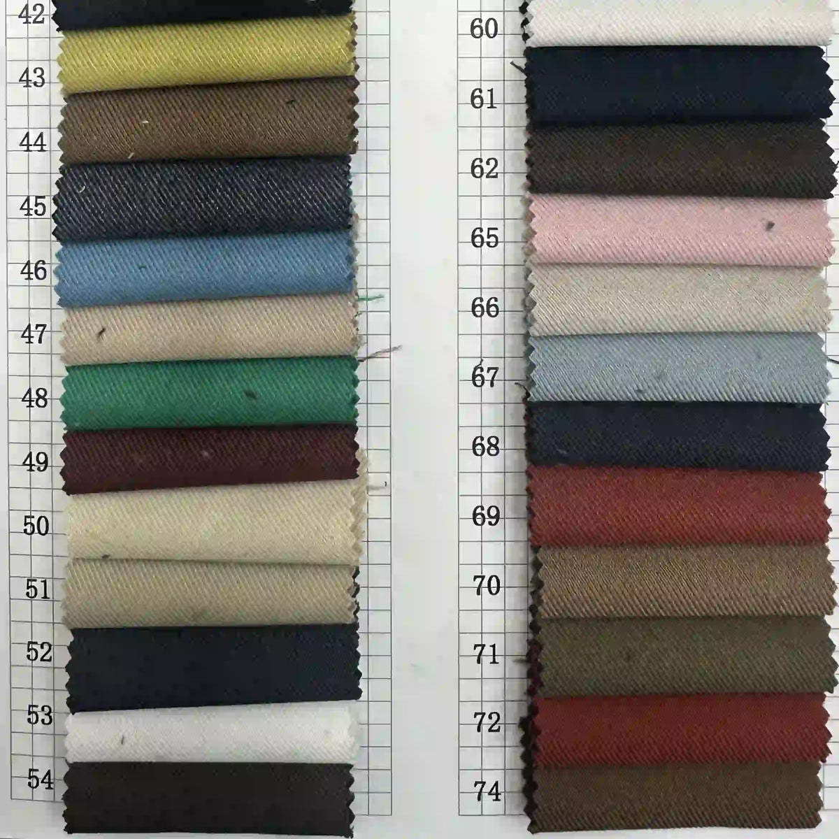 Deux colonnes d'échantillons de tissus, numérotés de 43 à 74, présentent des couleurs unies et des textures de la gabardine Longan Craft France Tissu gabardine stretch multicolore au mètre - une viscose polyvalente idéale pour les uniformes personnalisés.