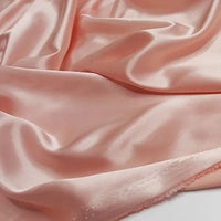 Gros plan sur le satin multicolore au mètre de Longan Craft France, un polyester soyeux parfait pour l'habillement, dont la texture lisse et la brillance douce sont mises en valeur par des plis élégants.