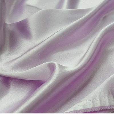Gros plan sur le Tissu en satin multicolore au mètre de Longan Craft France, de couleur lilas, aux plis souples et à la surface en polyester brillant et réfléchissant, idéal pour les vêtements et au fini soyeux.