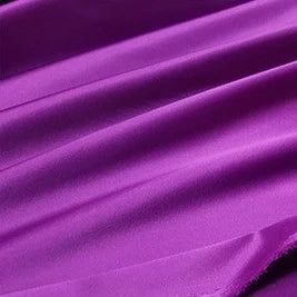 Gros plan sur un tissu de satin lisse et multicolore de Longan Craft France, à la surface légèrement brillante et douce et aux plis fluides, idéal pour les vêtements.