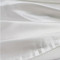 Un gros plan du tissu en satin multicolore au mètre de Longan Craft France montre sa surface lisse et brillante en polyester et ses plis doux - idéal pour vêtements et parfait comme tissu satin pour robes.