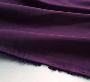 Un gros plan du tissu en satin multicolore au mètre de Longan Craft France montre sa texture polyester lisse et soyeuse et son bord légèrement effiloché, idéal pour les peignoirs et les vêtements.