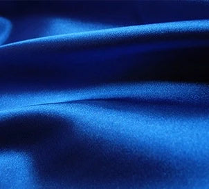 Gros plan sur un tissu en satin multicolore lisse et brillant de Longan Craft France, mettant en valeur sa texture luxueuse. Ce tissu en satin de polyester est idéal pour la confection de vêtements et de peignoirs élégants, vendus au mètre.