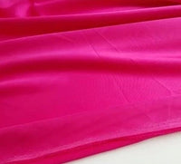 Un tissu de satin lisse et multicolore de Longan Craft France est étalé, révélant sa surface de polyester brillante et légèrement réfléchissante avec des plis souples - idéal pour la confection de vêtements.