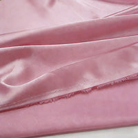 Gros plan sur le tissu satin polyester multicolore au mètre de Longan Craft France, qui présente un éclat doux et une texture délicate, avec de légers plis et des bords effilochés - idéal pour les vêtements.