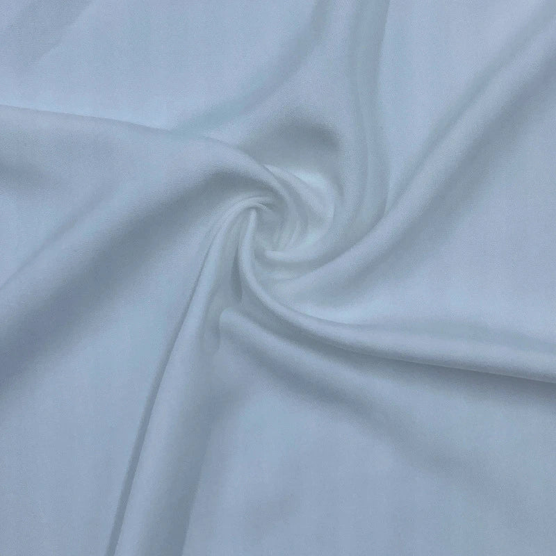 Gros plan sur le Satin de viscose multicolore de Longan Craft France, un tissu 100 % viscose qui présente des plis lisses et souples partant du centre - un choix élégant pour les robes du soir.